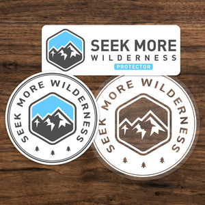 Seek More Wilderness Stickers on Wood Background